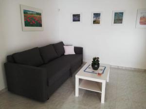 Casa Nica في موديكا: غرفة معيشة مع أريكة سوداء وطاولة