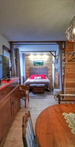1 dormitorio con 1 cama y 1 mesa en una habitación en La grange de Lina, en Grignon