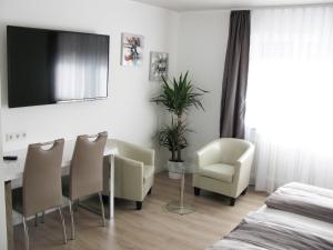 a dining room with a table and chairs and a television at Murgtal Motel in Rastatt
