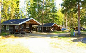 a cabin in the woods with a car parked in front at Lomakylä Timitraniemi in Lieksa