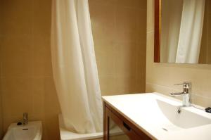 ein Badezimmer mit Waschbecken und Duschvorhang in der Unterkunft Gestiona2R - Apartamento 3 Habitaciones Landaburu in Posada de Llanes + 21 Fotos