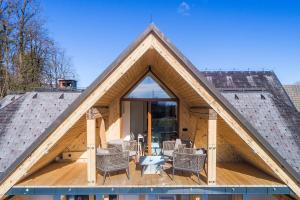 uma casa de madeira com uma grande janela e cadeiras em Apartment Wellness Essense em Bled