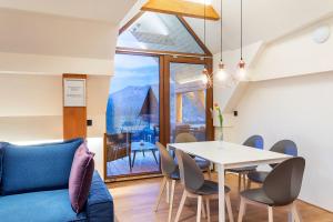 a living room with a blue couch and a table and chairs at Apartment Wellness Essense in Bled