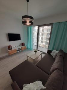 een woonkamer met een bank en een flatscreen-tv bij Apartament Aniutka in Międzyzdroje