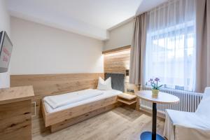 A bed or beds in a room at Gasthof Schroll