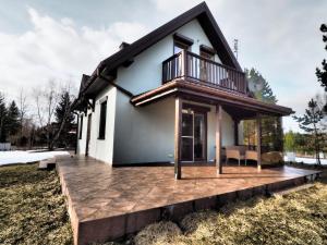 a home with a deck and a house at Horyzont Wałpusz in Szczytno