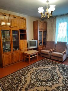 a living room with a couch and a tv at Эконом вариант - спальный район in Chernihiv