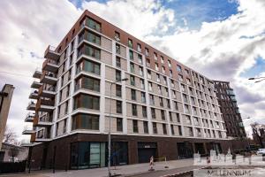 a large building on a city street with a sky at JM Millennium Port in Warsaw