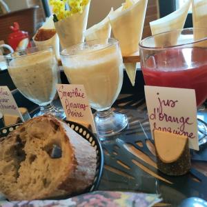 einen Tisch mit Gläsern und einem Teller Brot in der Unterkunft la fermette des grains dorés in Lafrançaise