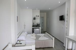 a white room with a bed and a kitchen at Aelia Sea View Studios in Afitos