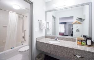 uma casa de banho com um lavatório, um WC e um espelho. em Brick Lodge Atlanta/Norcross em Norcross