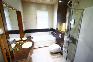 ein Badezimmer mit einer Badewanne, einem Waschbecken und einem WC in der Unterkunft Mascot Houseboats in Srinagar