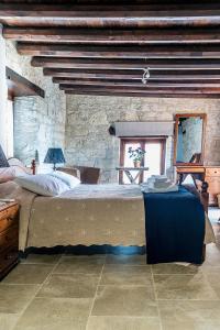 a bedroom with a large bed and a stone wall at To Konatzi tou Flokka in Ayios Theodhoros