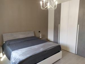 1 dormitorio con cama y lámpara de araña en Appartamenti con 1 e 2 camere Caldiero, en Caldiero