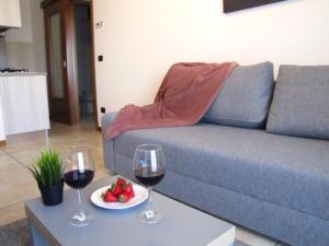 two glasses of wine and a plate of fruit on a table at Vicenza City Apartments 2 in Vicenza