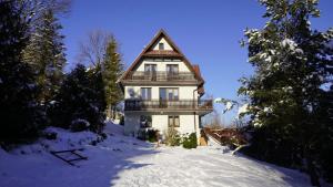 a house in the snow with a balcony on it at Zawoja Dom Czatoża in Zawoja