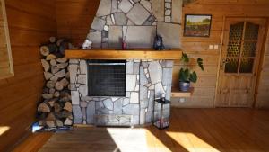 a room with a stone fireplace in a cabin at Zawoja Dom Czatoża in Zawoja