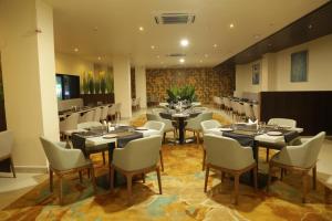 a restaurant with tables and chairs in a room at Hotel Vdara in Vijayawāda
