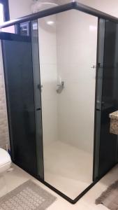 a glass shower in a bathroom with a toilet at Studio Julio Cezar in Foz do Iguaçu