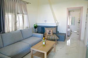 a living room with a blue couch and a table at Aelia Sea View Studios in Afitos