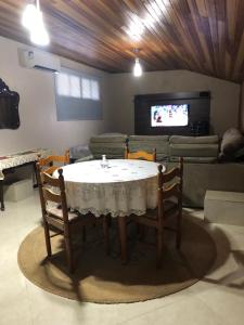 uma mesa e cadeiras numa sala de estar com um sofá em Studio Julio Cezar em Foz do Iguaçu