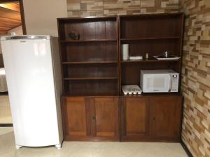 una cocina con nevera y microondas en Studio Julio Cezar, en Foz do Iguaçu