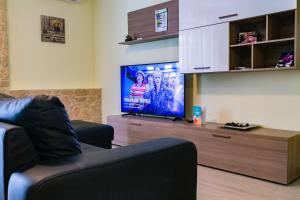 un soggiorno con 2 sedie e una TV a schermo piatto di Like at home ad Alghero