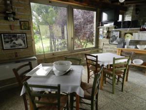 comedor con mesa, sillas y ventana en Pit Stop, en Campagnano di Roma