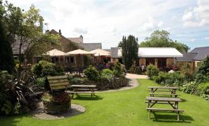 a group of picnic tables in a garden at Three Horseshoes Country Inn in Leek