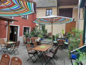 an outdoor patio with tables and chairs and umbrellas at Hotel Ehinger Rose in Ehingen