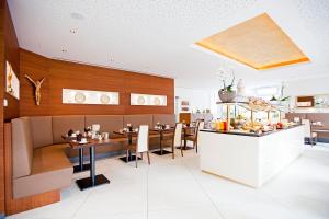 ein Restaurant mit einem Speisesaal mit Tischen und Stühlen in der Unterkunft Hotel Krone OHG in Gerlingen