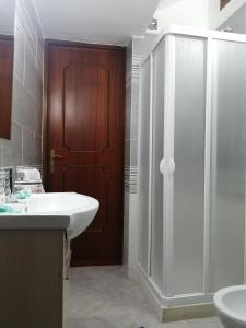 y baño con lavabo blanco y ducha. en Casa Amaranto, en Terrasini