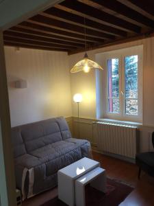 een woonkamer met een bank en een raam bij L' Huis-au-Tilleul in Quarré-les-Tombes