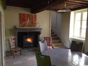 een woonkamer met een tafel en een open haard bij L' Huis-au-Tilleul in Quarré-les-Tombes