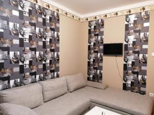 a living room with a couch and a wall with pictures at Margit Apartman in Hajdúszoboszló