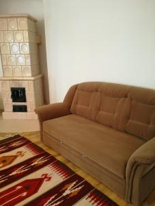 a brown couch in a living room with a fireplace at Hanga Apartman, Kőszeg in Kőszeg