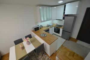 Apartment 54 CITY CENTER - FREE PRIVATE GARAGE في نوفي ساد: اطلالة علوية على مطبخ مع طاولة وثلاجة
