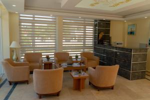 Ein Wartezimmer mit Stühlen, Tischen und einem Tresen in der Unterkunft Elijah Hotel in Kemer