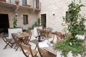an outdoor patio with wooden tables and chairs at Residence San Martino - Rooms & Suite Apartments in Erice