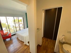a bedroom with a bed and a bathroom with a window at Vittorio 55 in La Plata