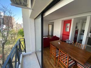 a balcony with a dining table and a living room at Vittorio 55 in La Plata