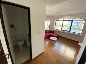 a living room with a red couch and a toilet at Vittorio 55 in La Plata