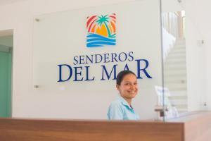 a woman standing at a podium in front of a sign at Senderos del Mar in Buritaca