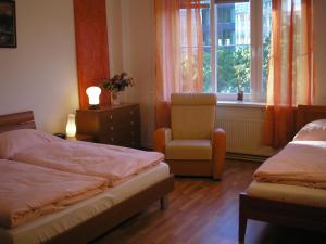 een slaapkamer met twee bedden en een stoel en een raam bij Apartment Accommodation up to 17 in Bratislava