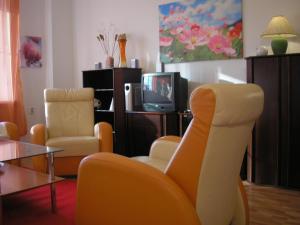sala de estar con 2 sillas y TV en Apartment Accommodation up to 17, en Bratislava