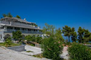 a large white building with trees and flowers at Aelia Sea View Studios in Afitos