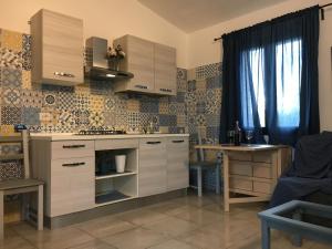 een keuken met witte kasten en een tafel en een raam bij Sa Tanca de Su Catreathu in Orosei