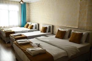 Zimmer mit 3 Betten und einem Fenster in der Unterkunft ada hotel in Istanbul