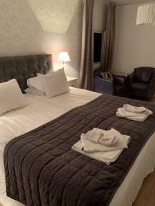 um quarto com uma cama com duas toalhas em Hotell Kaprifol em Hunnebostrand