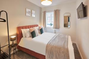 a bedroom with a large white bed and a window at Host & Stay - Endeavour Apartments in Whitby